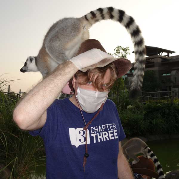 A photo of John with a lemur on his head